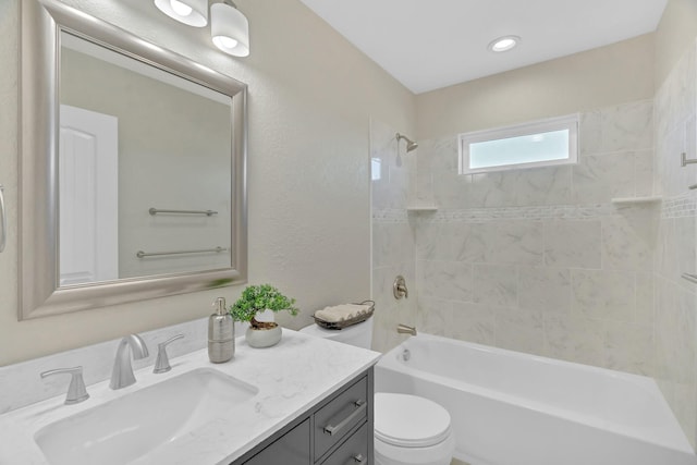 bathroom featuring toilet, a textured wall, shower / tub combination, and vanity