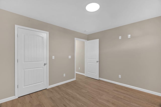 unfurnished bedroom featuring light wood-type flooring and baseboards