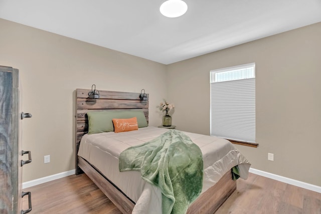 bedroom featuring wood finished floors and baseboards