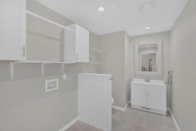 laundry room featuring laundry area, washer hookup, a sink, baseboards, and radiator heating unit