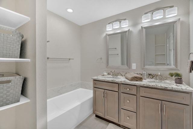 full bath with double vanity, a sink, and a bath