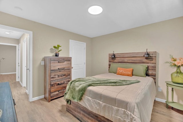 bedroom with light wood finished floors and baseboards