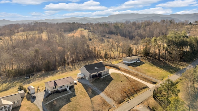 birds eye view of property featuring a rural view, a mountain view, and a view of trees