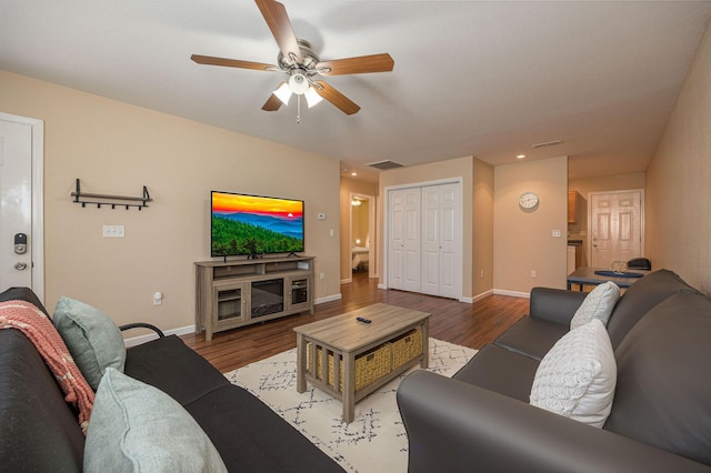 living area featuring visible vents, a ceiling fan, baseboards, and wood finished floors