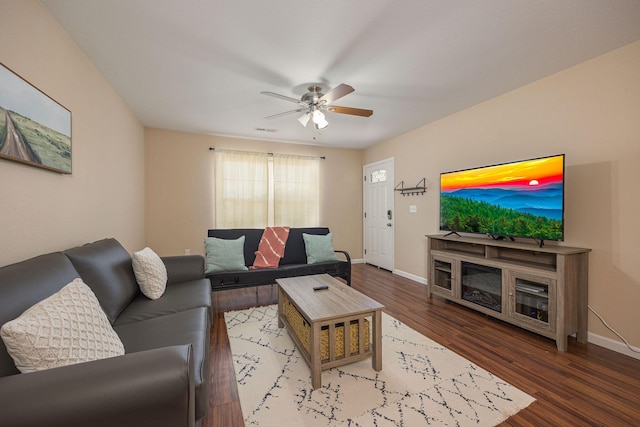 living area with a ceiling fan, baseboards, visible vents, and wood finished floors