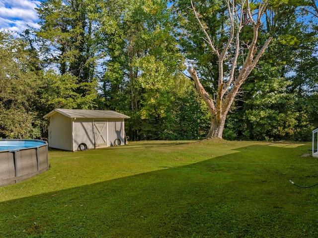 view of yard featuring an outdoor pool, a storage unit, and an outdoor structure