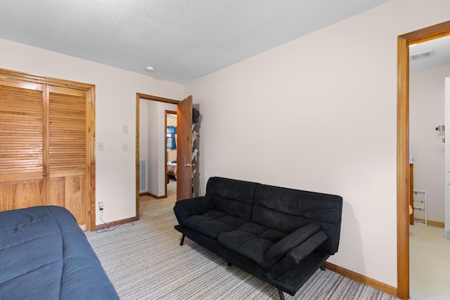 bedroom with a textured ceiling, visible vents, baseboards, and light carpet