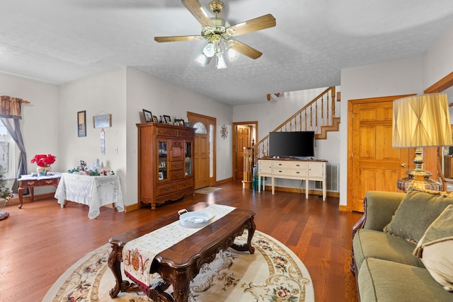 living room featuring a textured ceiling, dark hardwood / wood-style flooring, and ceiling fan