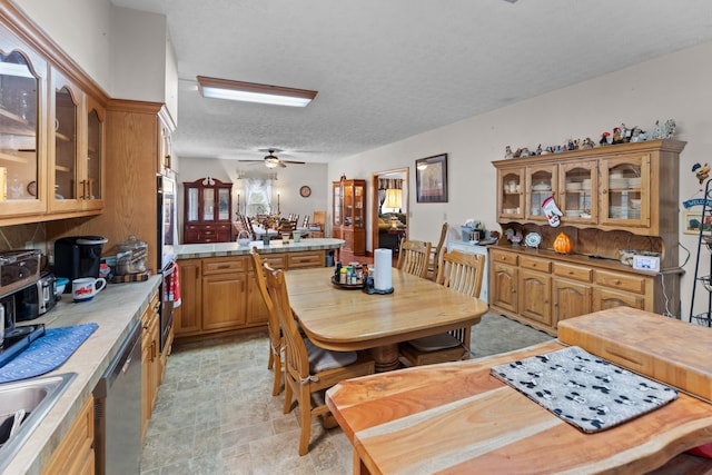 dining area with a textured ceiling, ceiling fan, and sink