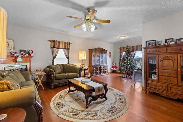 living room featuring a textured ceiling, dark hardwood / wood-style floors, and ceiling fan