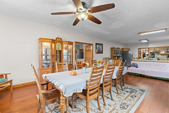 dining space featuring ceiling fan, light hardwood / wood-style floors, and a textured ceiling