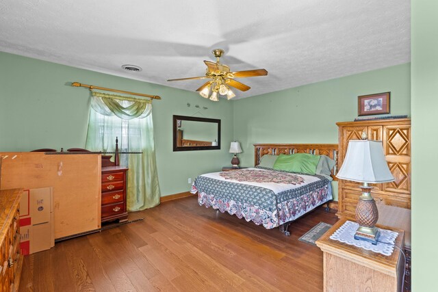 bedroom featuring ceiling fan, a textured ceiling, and hardwood / wood-style flooring