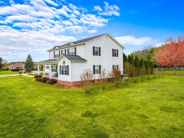 back of property featuring a yard and a porch