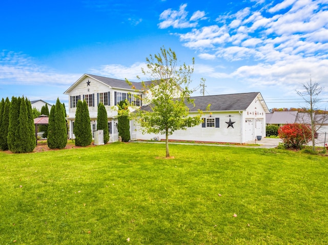 back of house with a garage and a yard