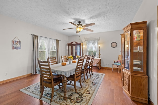 dining area featuring ceiling fan, hardwood / wood-style floors, and a textured ceiling