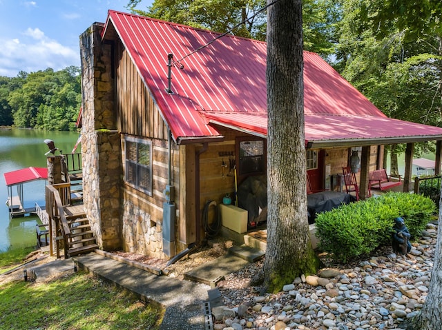 1055 Dean Cir, Dandridge, TN 37725 - view of front facade featuring stone siding, a water view, a metal roof, and a boat dock