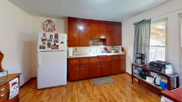 kitchen featuring sink, white fridge, and light hardwood / wood-style floors