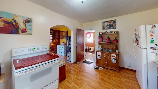 kitchen featuring light hardwood / wood-style floors and white appliances