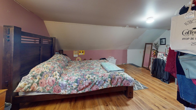 bedroom with lofted ceiling and light hardwood / wood-style flooring