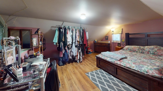 bedroom with light hardwood / wood-style flooring and lofted ceiling