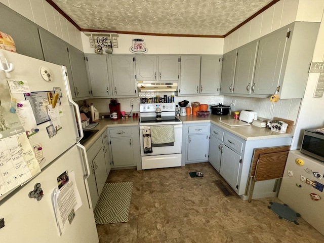 kitchen featuring ornamental molding, light countertops, white appliances, and under cabinet range hood