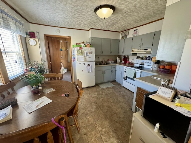 kitchen featuring ornamental molding, white appliances, a sink, and under cabinet range hood