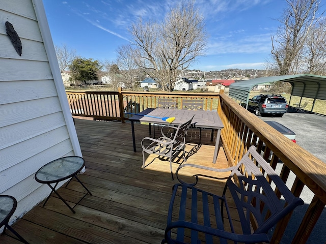 deck with a detached carport and outdoor dining area