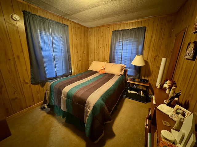 bedroom with carpet, wooden walls, and a textured ceiling