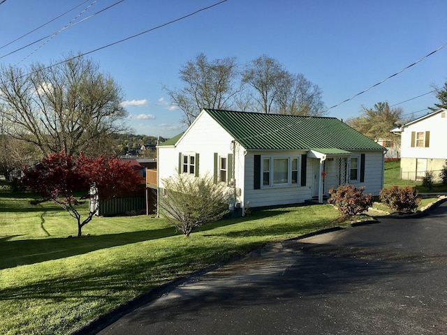 view of front of property with metal roof, a standing seam roof, and a front yard