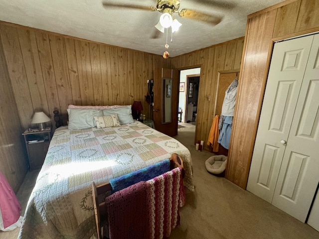 carpeted bedroom with wooden walls, a ceiling fan, and a textured ceiling