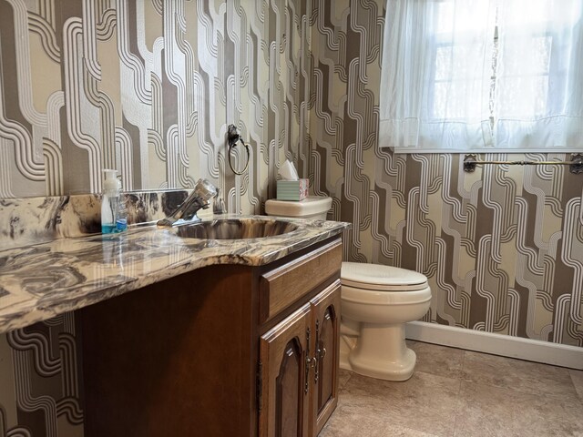 bathroom featuring tile patterned flooring, toilet, and vanity