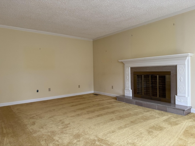 unfurnished living room featuring a tile fireplace, crown molding, and carpet floors