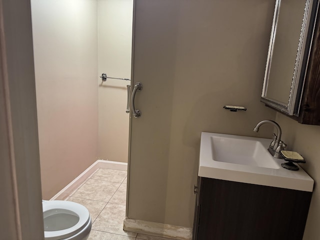 bathroom featuring tile patterned floors, baseboards, toilet, and vanity