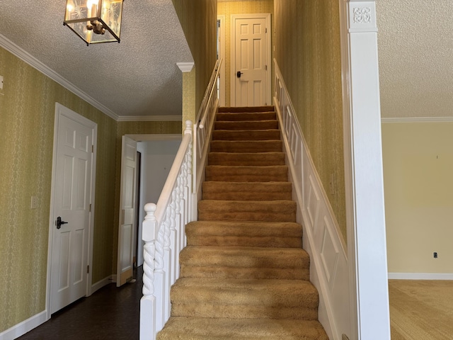 stairway with wallpapered walls, crown molding, an inviting chandelier, and a textured ceiling