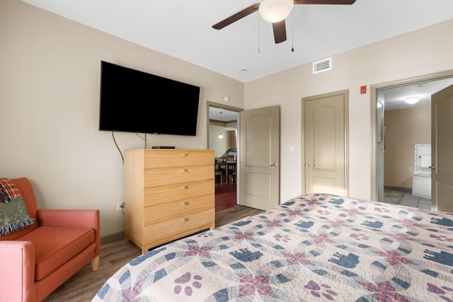 bedroom with hardwood / wood-style floors, ensuite bath, and ceiling fan