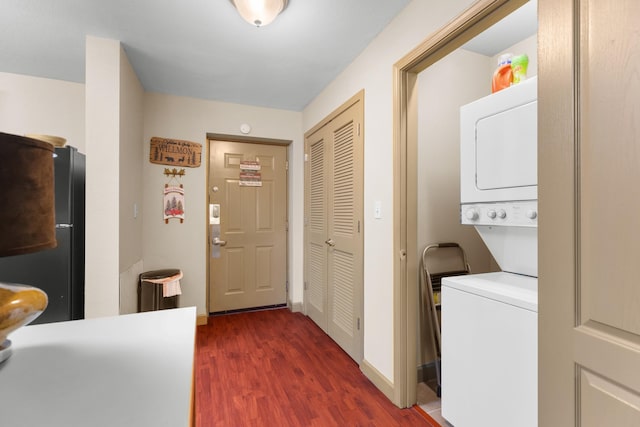 washroom featuring stacked washing maching and dryer and dark hardwood / wood-style flooring
