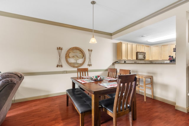 dining space featuring dark hardwood / wood-style flooring and crown molding