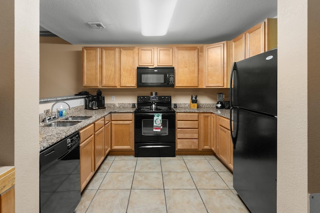 kitchen with black appliances, light stone countertops, light tile patterned floors, sink, and light brown cabinets