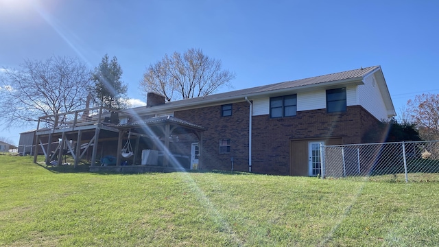 back of house with a deck and a yard