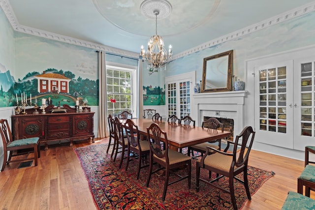 1130 Squirewood Way, Dandridge, TN 37725 - dining room with a chandelier, wood-type flooring, a fireplace, french doors, and wallpapered walls