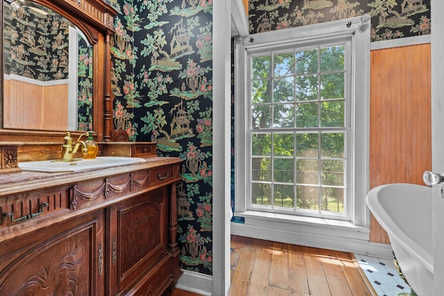1130 Squirewood Way, Dandridge, TN 37725 - bathroom with wallpapered walls, a freestanding tub, vanity, wood-type flooring, and baseboards