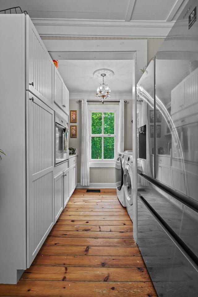 1130 Squirewood Way, Dandridge, TN 37725 - laundry room featuring washer and clothes dryer, a chandelier, light wood finished floors, cabinet space, and crown molding