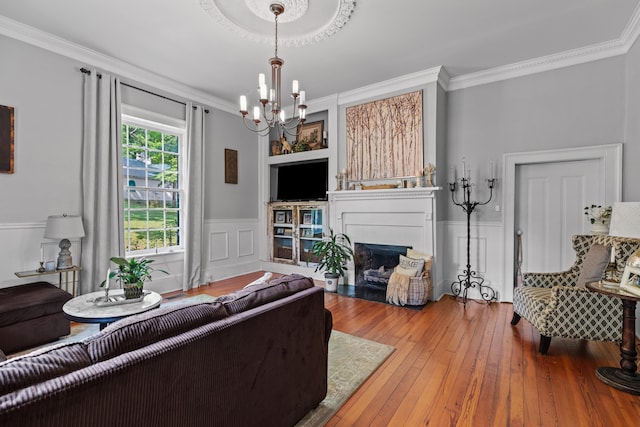 1130 Squirewood Way, Dandridge, TN 37725 - living room featuring a chandelier, crown molding, wood-type flooring, a fireplace with flush hearth, and wainscoting