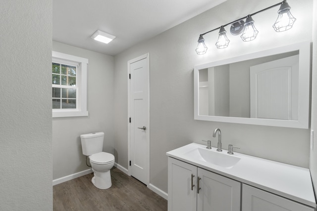 bathroom with hardwood / wood-style flooring, vanity, and toilet