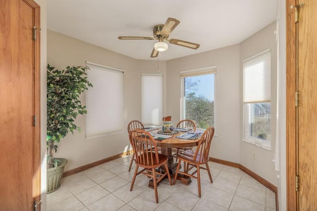 dining space featuring light tile patterned floors, ceiling fan, and baseboards