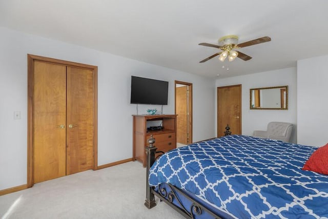 bedroom with a ceiling fan, light carpet, and baseboards