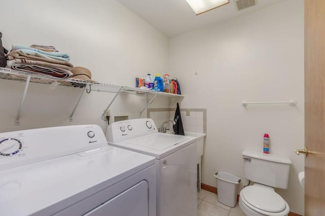 laundry area with light tile patterned floors, laundry area, baseboards, visible vents, and washer and clothes dryer