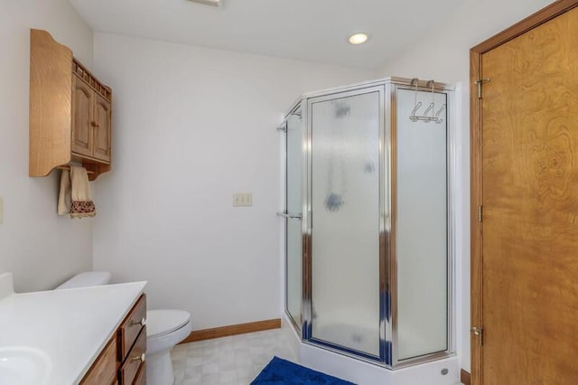 full bath featuring a stall shower, toilet, vanity, and baseboards