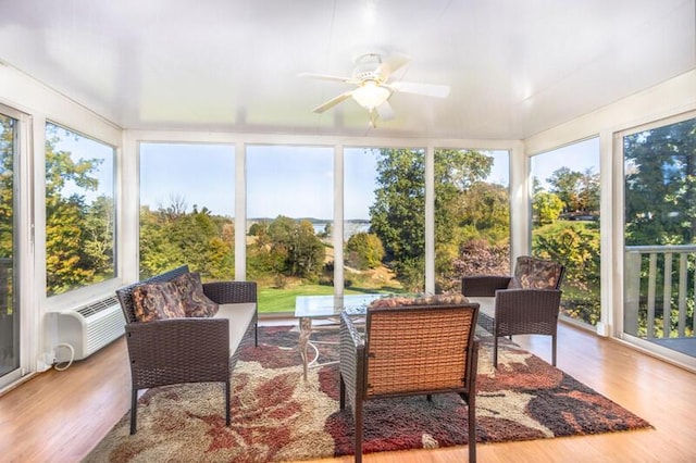 sunroom / solarium with an AC wall unit, plenty of natural light, and ceiling fan