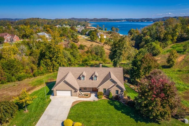 birds eye view of property featuring a water view and a wooded view